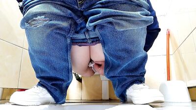 Hot MILF in jeans pissing in a public restroom